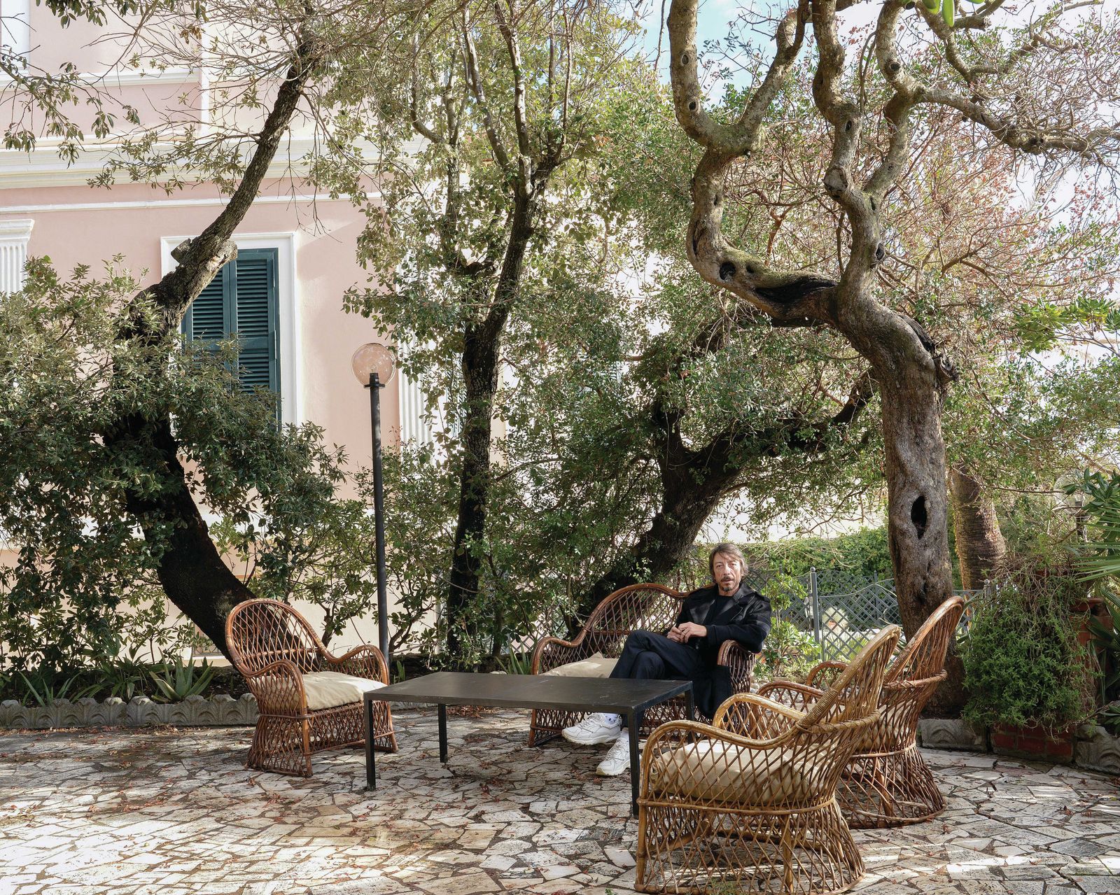 Image may contain Massimo Ceccherini Chair Furniture Adult Person Clothing Footwear Shoe Plant Sitting and Table