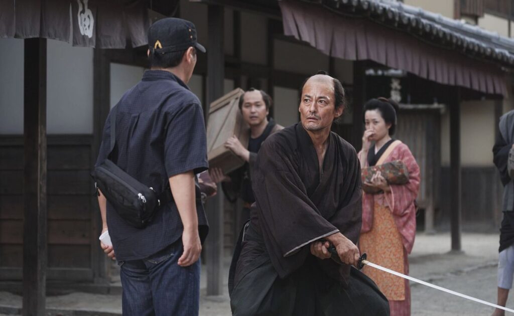 現代の時代劇撮影所にタイムスリップしてしまった主人公・高坂新左衛門（右）（Ｃ）２０２４　Ｓａｍｕｒａｉ　Ｔｉｍｅ　Ｓｌｉｐｐｅｒ．　Ａｌｌ　Ｒｉｇｈｔｓ　Ｒｅｓｅｒｖｅｄ