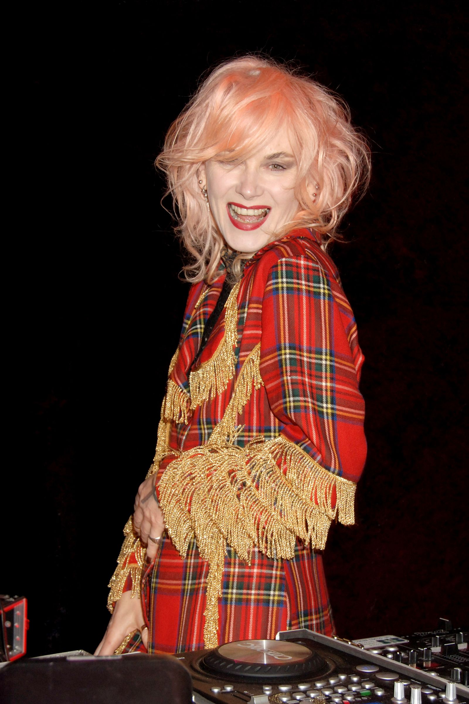 Image may contain Pam Hogg Blonde Hair Person Face Happy Head Adult Photography Portrait Laughing and Tartan
