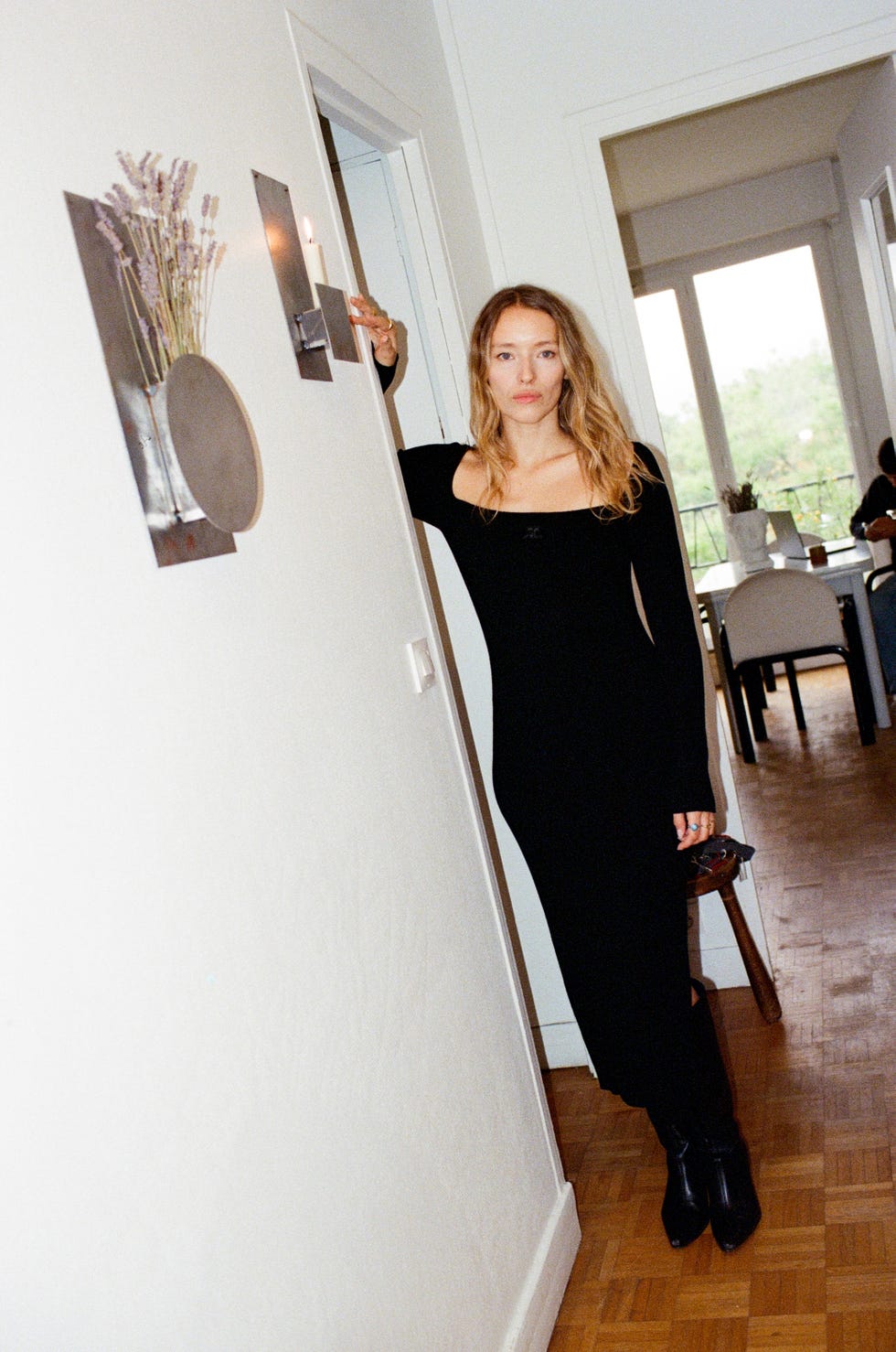 woman in a black dress standing in a hallway