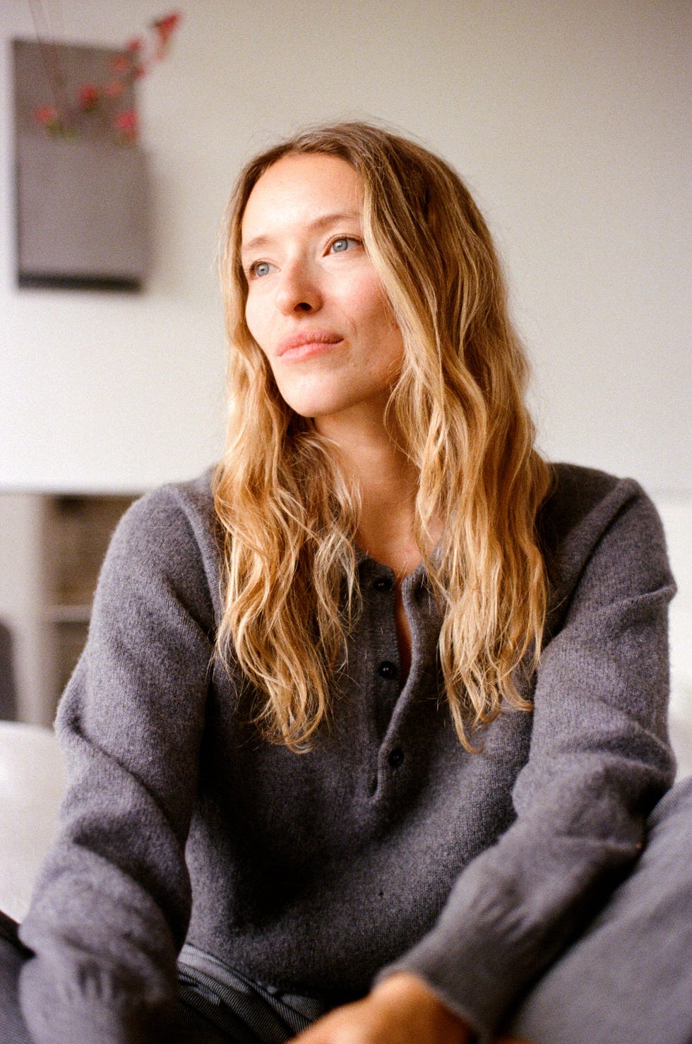 person sitting indoors wearing a gray sweater