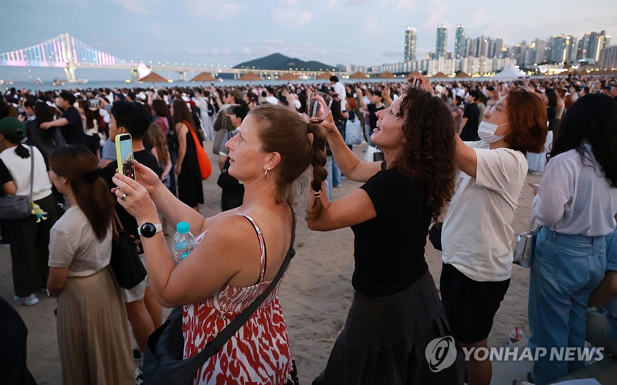 韓国南部、釜山の広安里海水浴場でドローンショーを楽しむ外国人観光客＝（聯合ニュース）