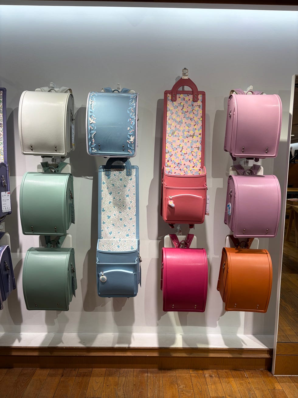 colorful backpacks displayed on wall hooks in a store.