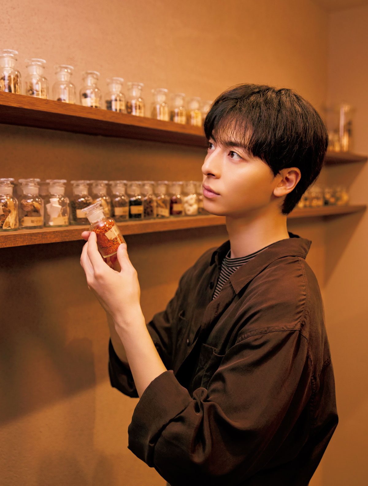 棚にずらりと並ぶ生薬を見ている様子